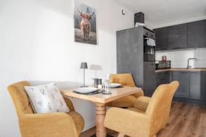 a kitchen with a wooden table and two chairs at Bergnest Iseler mit Panoramablick in Oberjoch