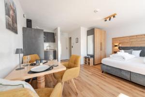 a bedroom with a bed and a table and chairs at Bergnest Iseler mit Panoramablick in Oberjoch
