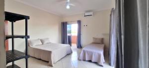 a room with a bed and a chair and a window at SOBRADO - ótimo custo beneficio - 3 quartos com ar in Campo Grande +61 photos