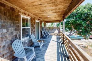 a porch with two chairs and a table at The Flying Dutchman OBX in Kill Devil Hills