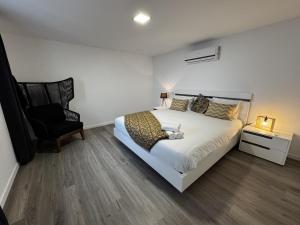 a bedroom with a large bed and a chair at Hiking & Ocean in Arco da Calheta