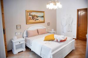 a bedroom with a white bed and a chandelier at CasaLina Perfect House in Altamura