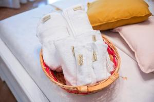 a basket of towels and pillows on a bed at CasaLina Perfect House in Altamura