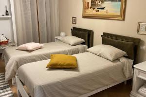 a room with three beds with a yellow pillow on them at CasaLina Perfect House in Altamura