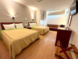 a hotel room with two beds and a window at Hotel Enterprise Inn Plaza in León