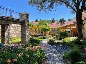 a garden with flowers and a stone pathway at TR 1823 Vendégház in Mád