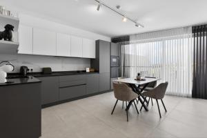 a kitchen with a table and chairs in a room at Top Floor Penthouse with Valletta Views & Terrace in Gwardamanġa +18 photos