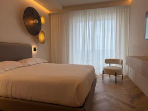 a bedroom with a bed and a chair and a window at Rumare - BADIA NUOVA in Trapani