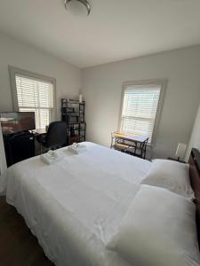 a bedroom with a large white bed and a desk at Boston Historic Lower Mills in Boston