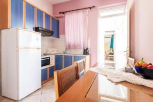a kitchen with blue cabinets and a white refrigerator at Workation Studio by the Sea in Velika