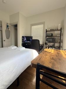 a bedroom with a large white bed and a desk at Boston Historic Lower Mills in Boston