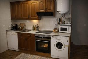 a kitchen with a stove and a sink and a dishwasher at Casa Rural Casa de Chocolate in Cuevas del Valle