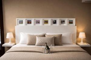 a bedroom with a large white bed with two lamps at Casa Rural Casa de Chocolate in Cuevas del Valle