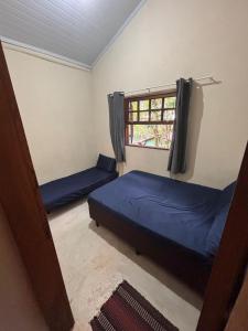 a bedroom with two beds and a window at Casa na Mata - 2 min da Praia de fora com WiFi in Paraty