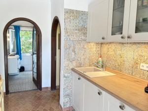 a kitchen with a sink and a door to a hallway at Cas Quinto in Cala Ratjada