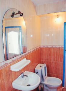 La salle de bains est pourvue d'un lavabo, de toilettes et d'un miroir. dans l'établissement Taghazout Surf House, à Taghazout