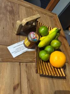 a basket of fruit with limes and bananas and a jar of honey at Le Bananawi in Pointe-Noire