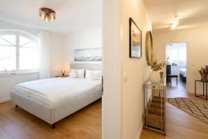 a white bedroom with a bed and a hallway at Villa Fabiola in Strandnähe in Binz