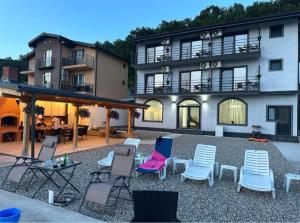 a group of chairs and tables in front of a building at Mala House in Orşova