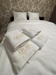 a bed with white towels with the word joy on it at The Urban Hide by D'or Selection in Bucharest