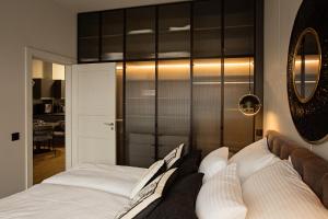 a bedroom with a bed with white pillows at Apartament Husarski - City Park in Poznań