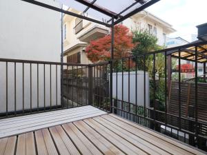 a balcony with a black fence and a wooden deck at Kanigaya House in Kawasaki +61 photos