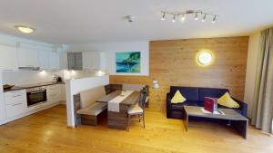 a kitchen and a living room with a couch and a table at Apartments Dolomit-Royal in Sillian