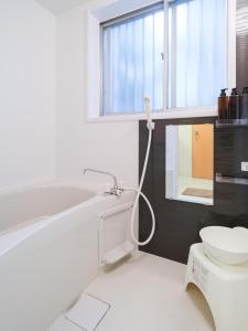 a bathroom with a white toilet and a sink at Kanigaya House in Kawasaki