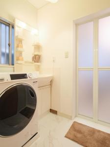 a white laundry room with a washing machine at Kanigaya House in Kawasaki