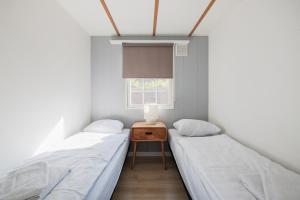 two beds in a room with a table and a window at 89, Beekse Bergen, Efteling, Nature, Kampina in Oisterwijk +20 photos