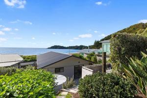 an aerial view of a house with the ocean in the background at Spectacular Woolleys Bay in Matapouri