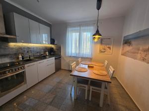 a kitchen with a table with chairs and a stove at Apartamenty Aquarius - Latarnik in Gdynia