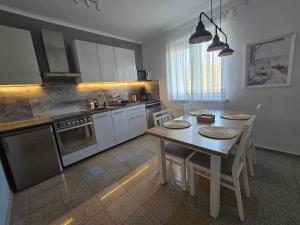 a kitchen with a wooden table and a dining room at Apartamenty Aquarius - Latarnik in Gdynia +20 photos