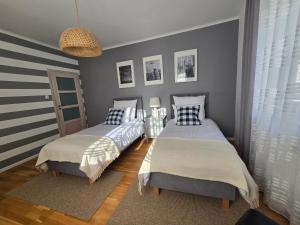 two beds in a room with gray walls at Apartamenty Aquarius - Latarnik in Gdynia