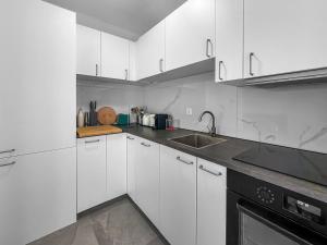 a white kitchen with white cabinets and a sink at Appartamento Rivamaggia Locarno in Solduno