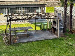 a picnic shelter with a table and a bench and a oven at Appartamento Rivamaggia Locarno in Solduno