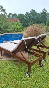 a wooden bed sitting in the grass next to a pool at Casa El Bosque in Candelaria
