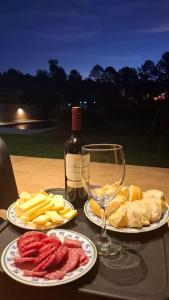 a table with two plates of food and a bottle of wine at Casa El Bosque in Candelaria