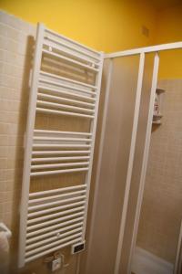 a white shutter door in a bathroom with a shower at Casa Broglia in Castel Santa Maria +8 photos