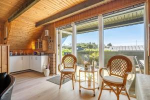 a kitchen and dining room with a table and chairs at 112-Ringkobing-Sletten-12 in Søndervig