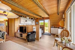 a kitchen and living room with a table and chairs at 112-Ringkobing-Sletten-12 in Søndervig