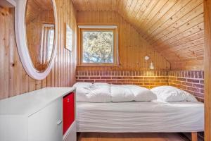 a bedroom with a bed in a wooden house at 112-Ringkobing-Sletten-12 in Søndervig