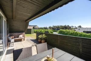 a patio with chairs and a wooden fence at 112-Ringkobing-Sletten-12 in Søndervig