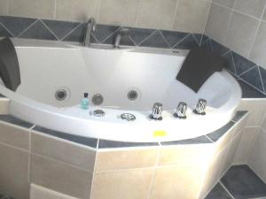 a white bath tub in a tiled bathroom at Himmelblau in Dabitz