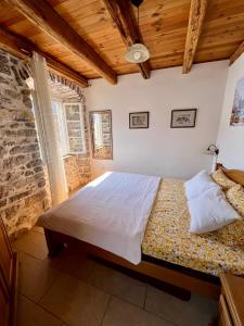 ein Schlafzimmer mit einem großen Bett in einem Zimmer in der Unterkunft Apartments Gudco in Perast