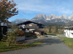 a road leading to a house with mountains in the background at Landhaus Wörgartner in Going am Wilden Kaiser