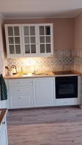 a kitchen with white cabinets and a sink at Ferienwohnung Wulkow in Großwulkow