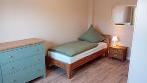 a small bedroom with a bed and a dresser at Ferienwohnung Wulkow in Großwulkow