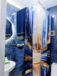 a blue bathroom with a shower curtain and a sink at Unique garden deluxe apartment in Trujillo +79 photos