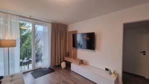 a living room with a television and a large window at Solovan Hill in Sighetu Marmaţiei